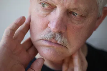 man checking his jaw for lumps